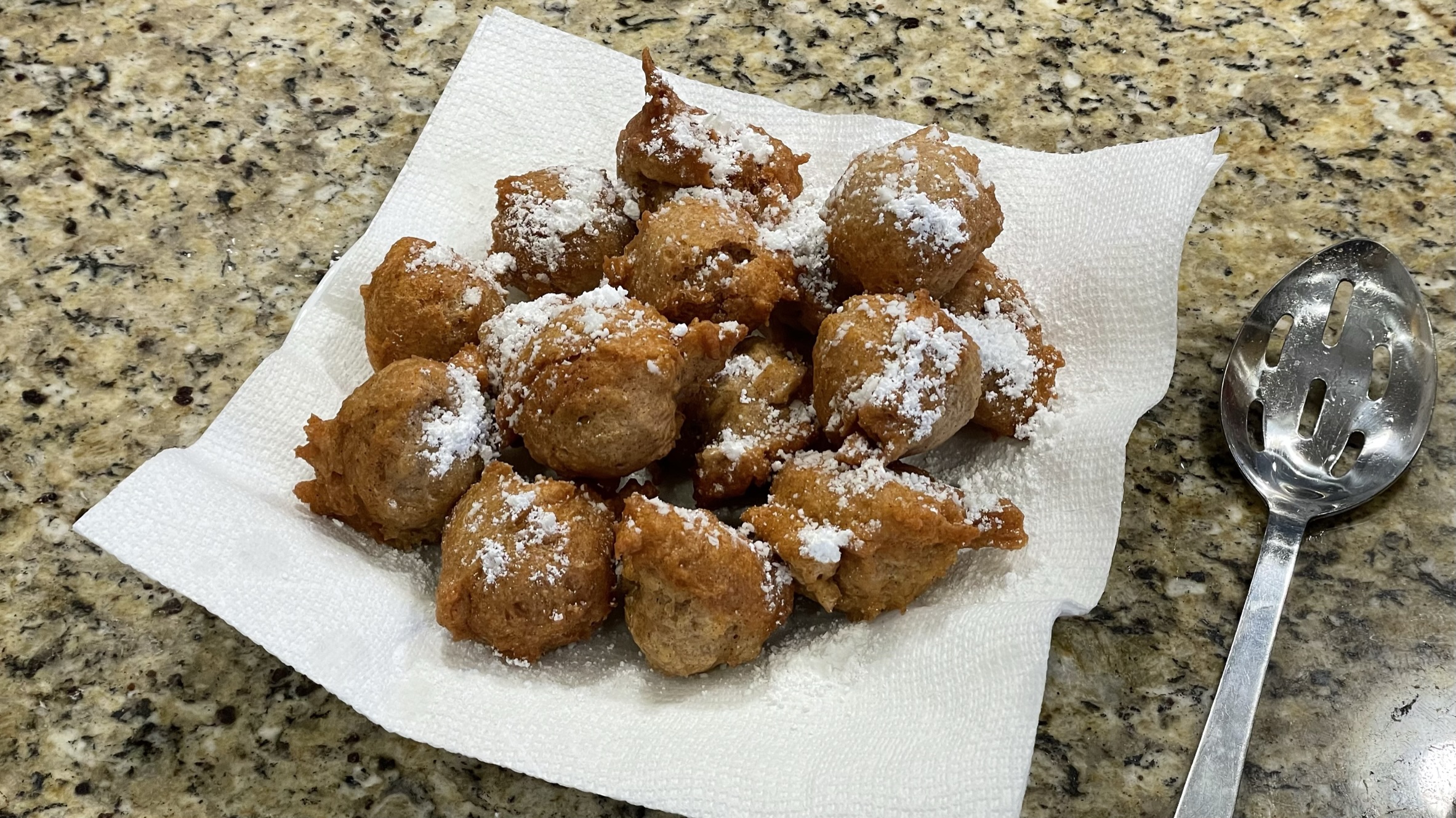 A plate of hot Apple Cinnamon Sinkers sprinkled with powdered sugar