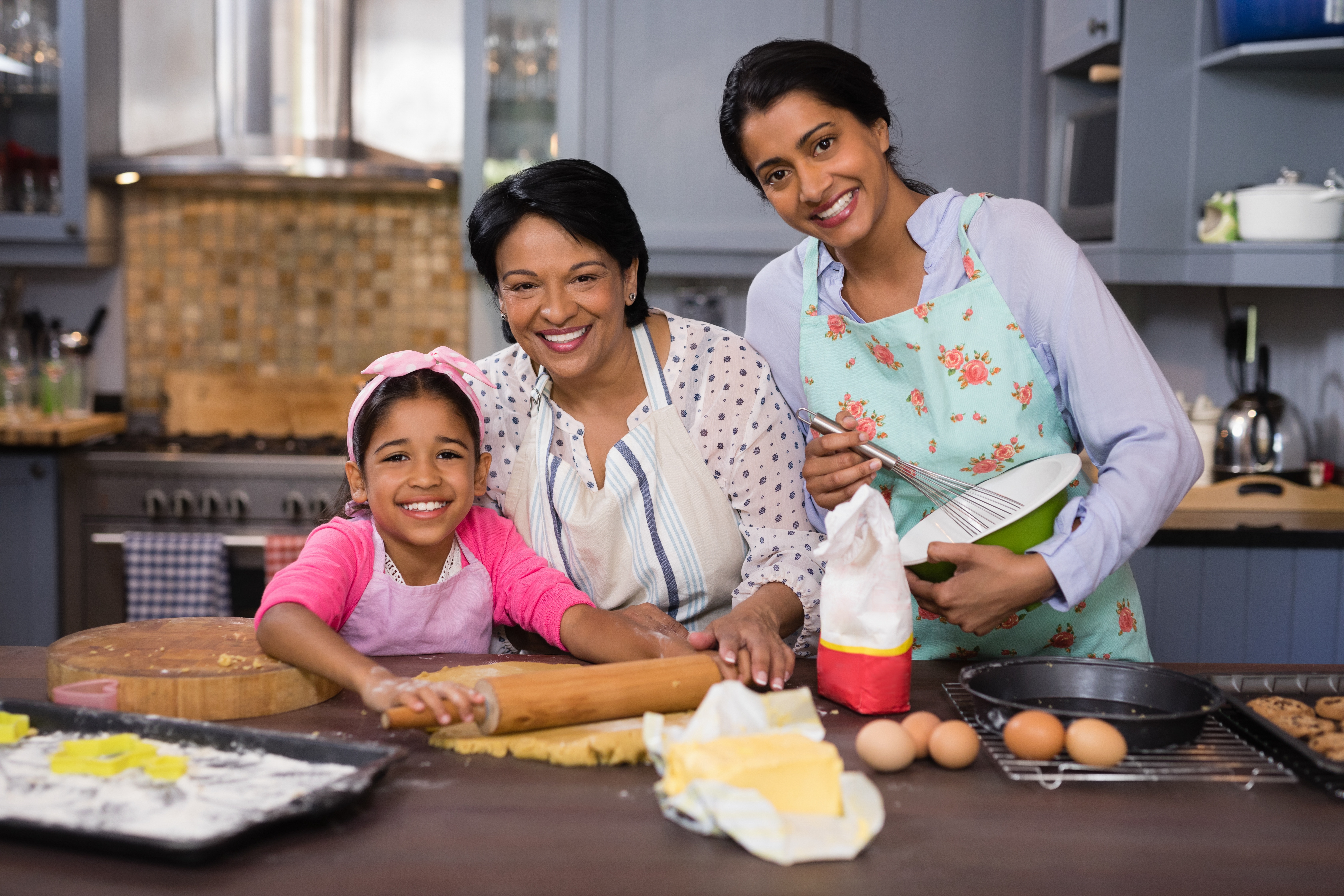 Smiling multi-generation family preparing food in kitchen