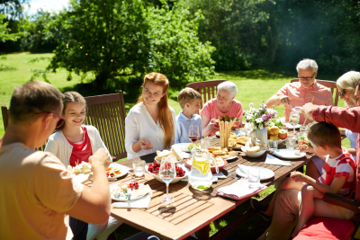 leisure, holidays and people concept - happy family having festive dinner or summer garden party
