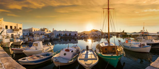 Panoramic views of the port of Naousa with the numerous bars and restaurants on the Cycladic island of Paros at sunset, Greece