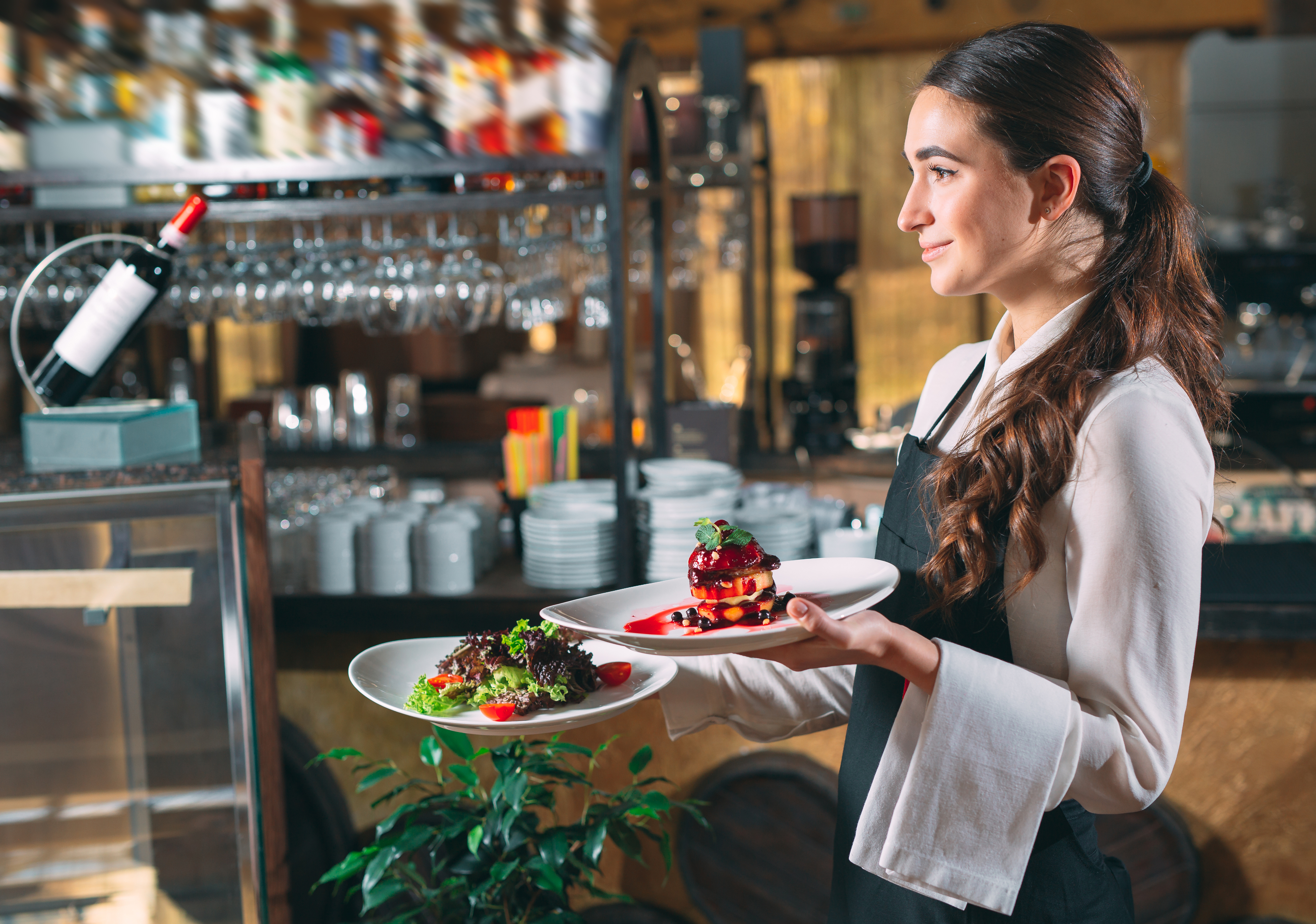 Waiter serving in motion on duty in restaurant. The waiter carries dishes