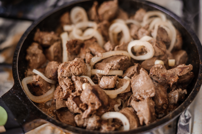 Fried veal liver with onions in a pan. Braised cow and pork liver