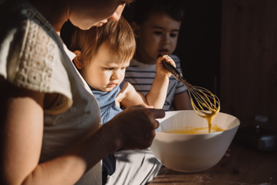 Mother helped by her kids baking cookies in kitchen. Cooking, together, kitchen, relationship.