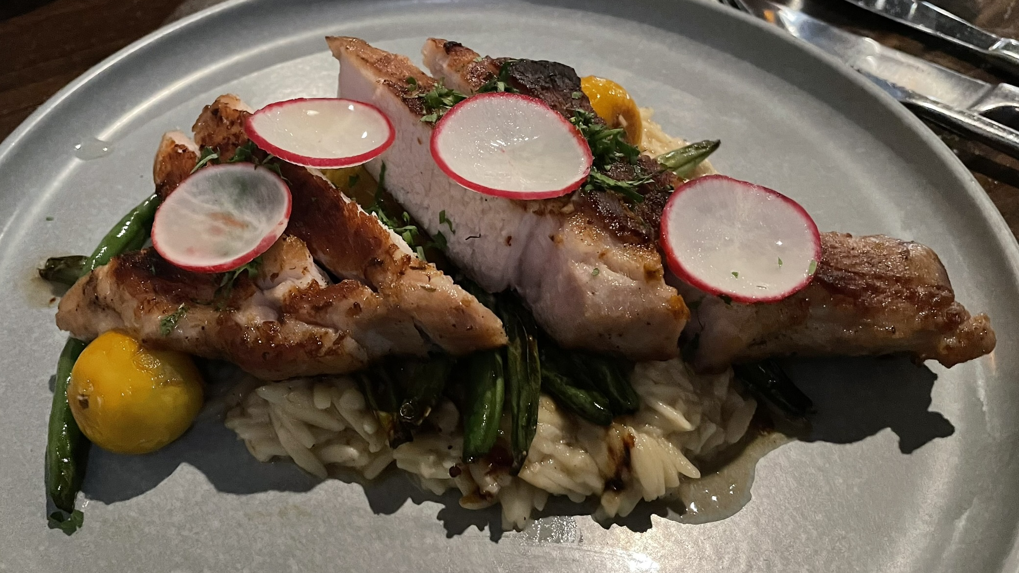 Niman Ranch Pork Loin with lemon & parmesan orzotto, green beans, cherry tomato, garlic honey, and parsley at the Block Restaurant