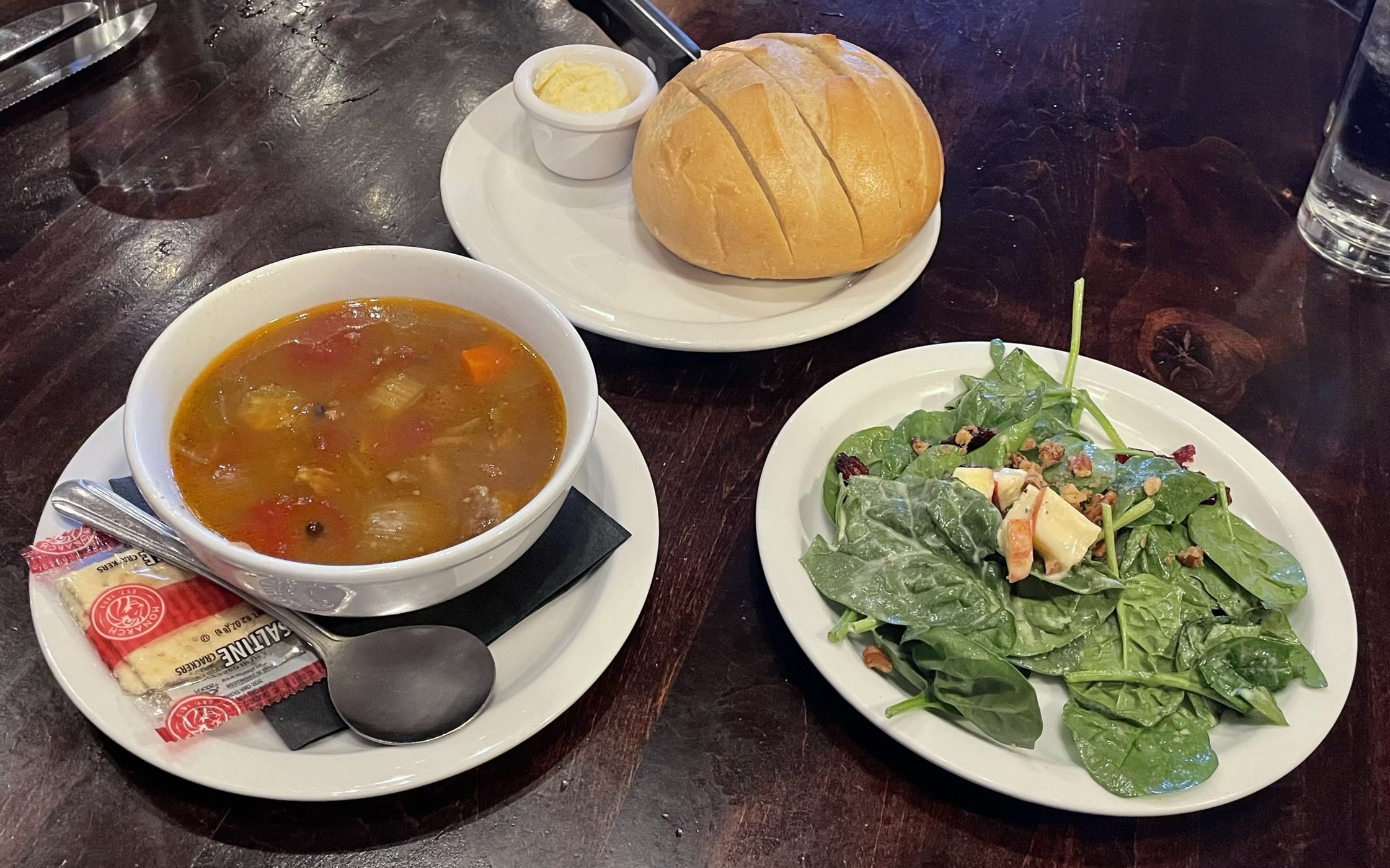 Soup, salad, and bread at Carvers Steak and Seafood restaurant.  Beef and Barley Soup (house made broth, small grain barley, vegetables, beef chunks), Spinach Salad (spinach lettuce, apples, cranberries, pecans, honey mustard dressing)