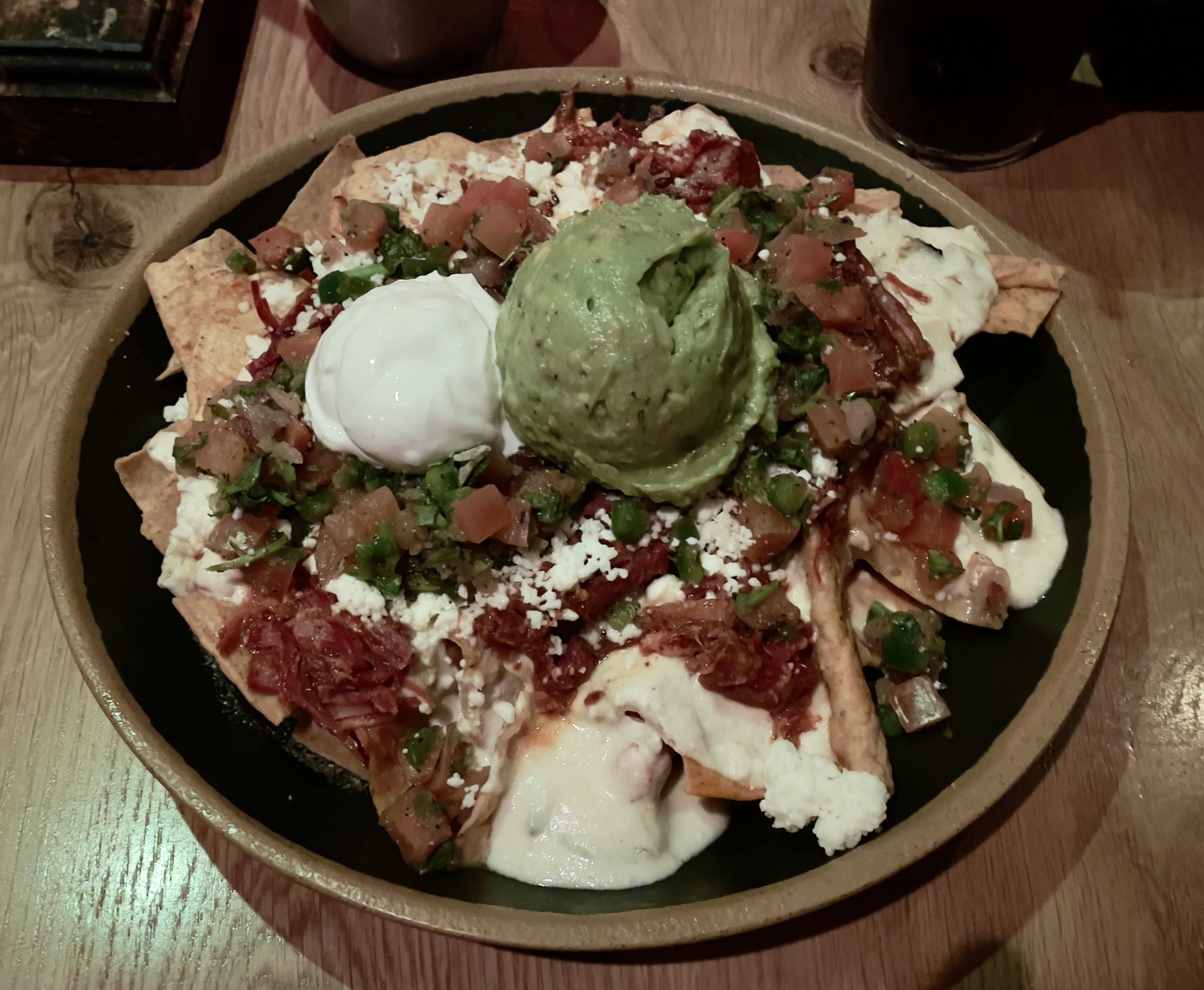 Carnitas Nachos at Casa Bonita.  House made tortilla chips, carnitas, queso blanco, pico de gallo, queso fresco, guacamole, and crema.