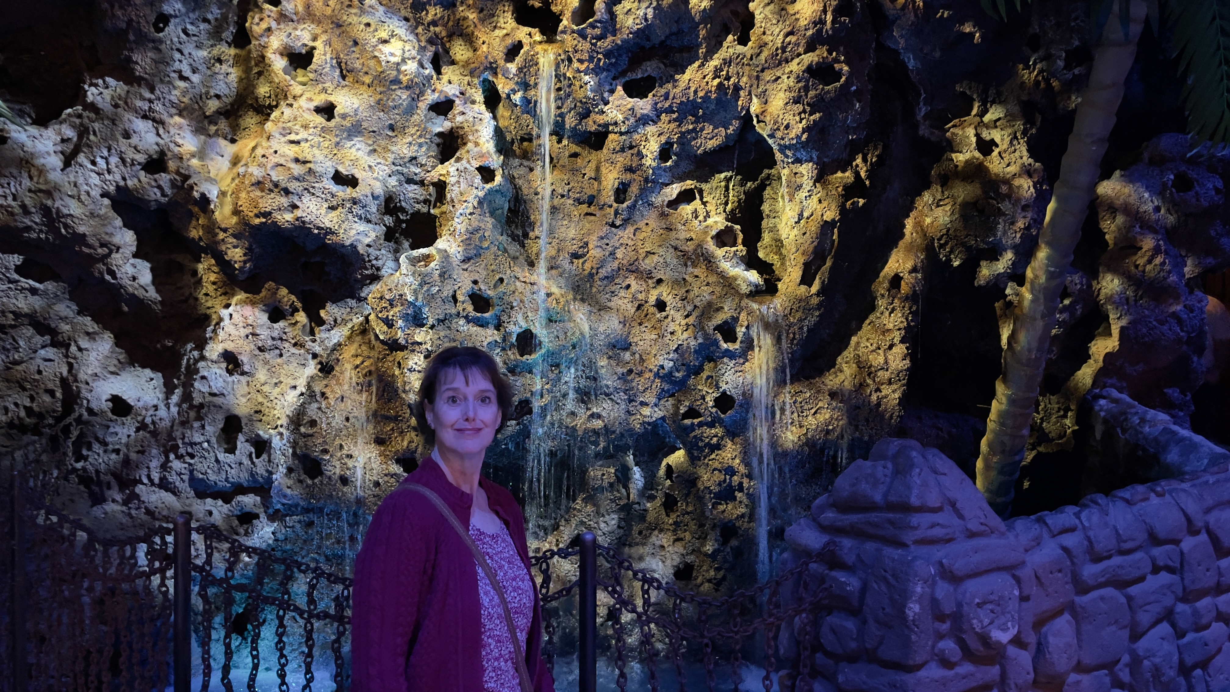 Kathy crosses a bridge at a seeping wall at Casa Bonita.