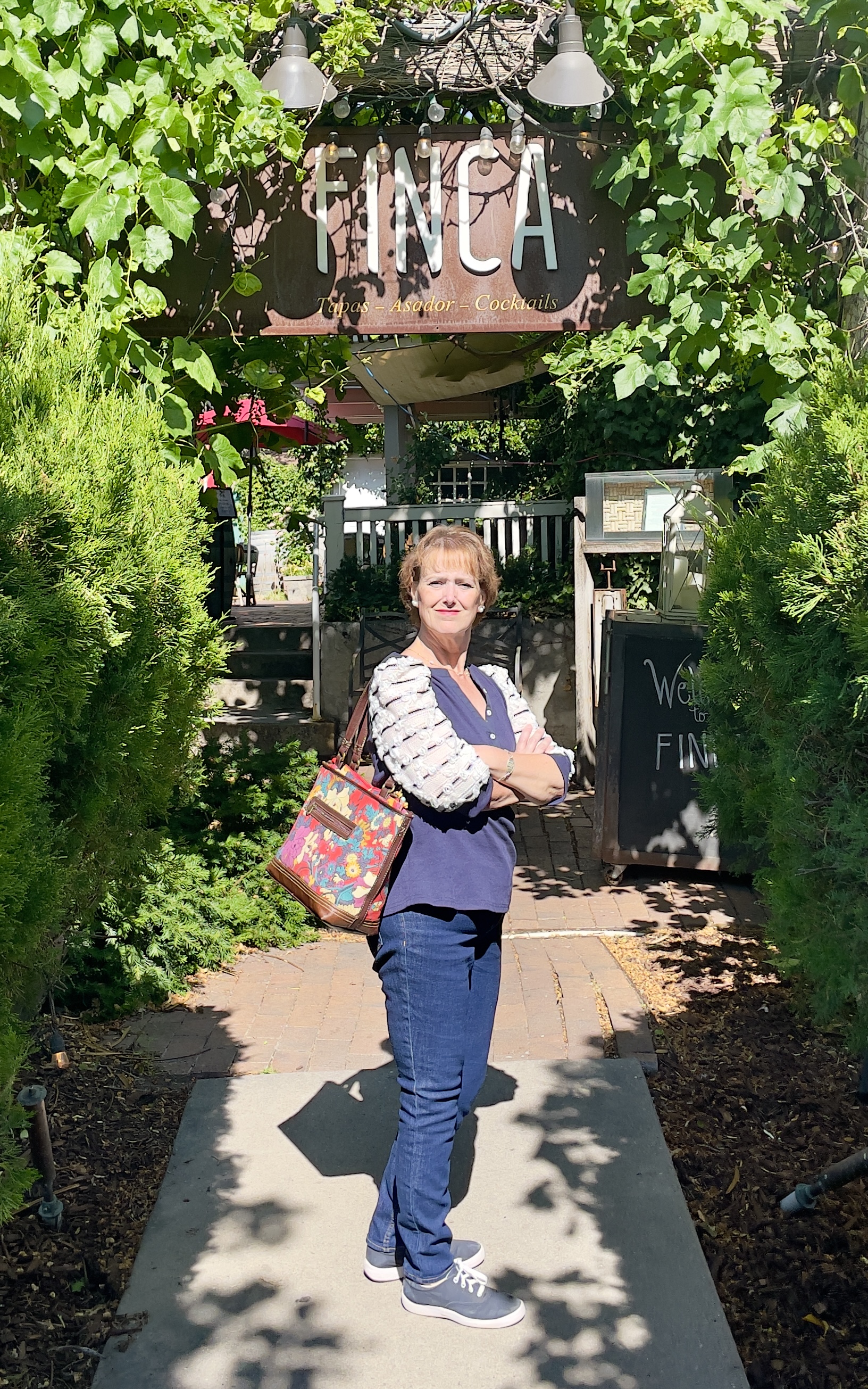Kathy stands in front of the ivy-draped entrance to Finca.