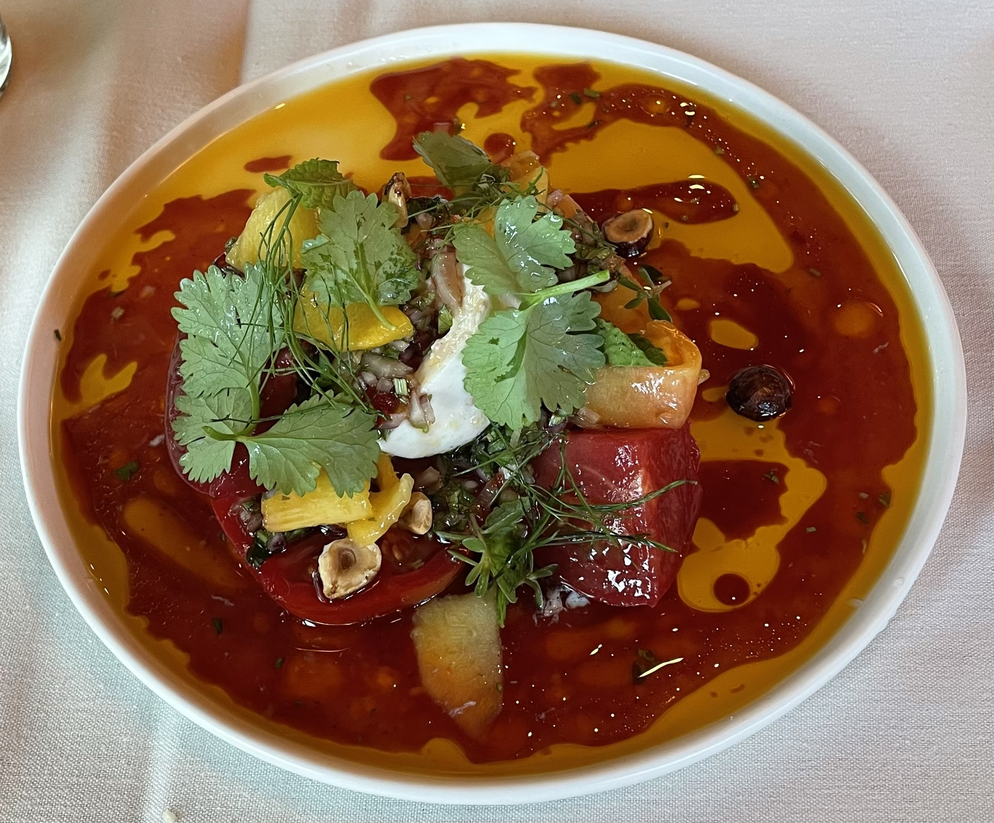 Mandi's Heirloom Tomatoes at Franck's Restaurant.  Burrata cheese, burgundy aguachile, half candied hazelnuts, Utah peach, wild onion XO, aromatic herbs.