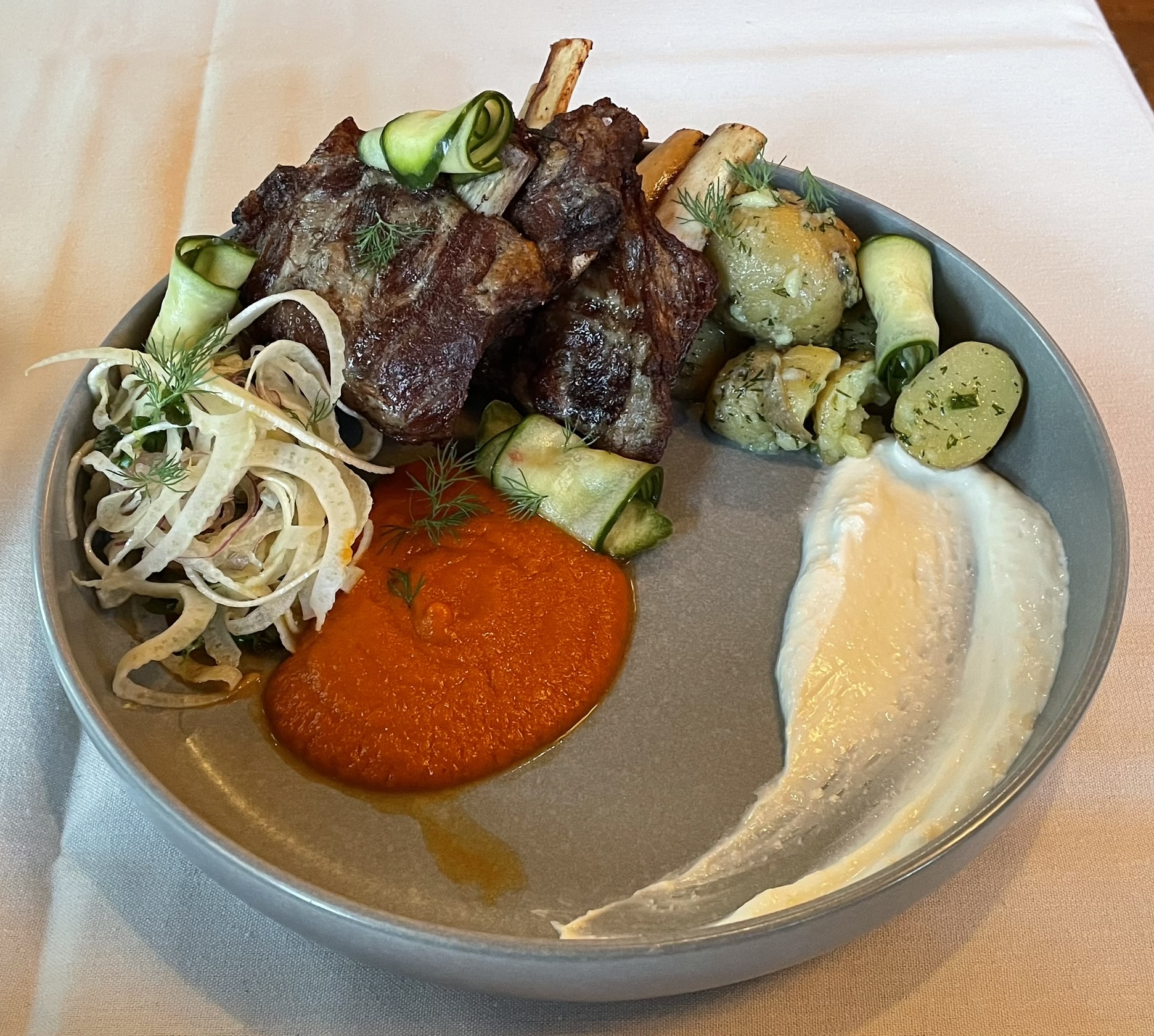 Crispy Braised Rocky Mountain Lamb Ribs at Franck's Restaurant.  Chilled dill potato, charred tomato & lemon sauce, chili cucumber, horseradish-goat cheese, fennel-herb salad.