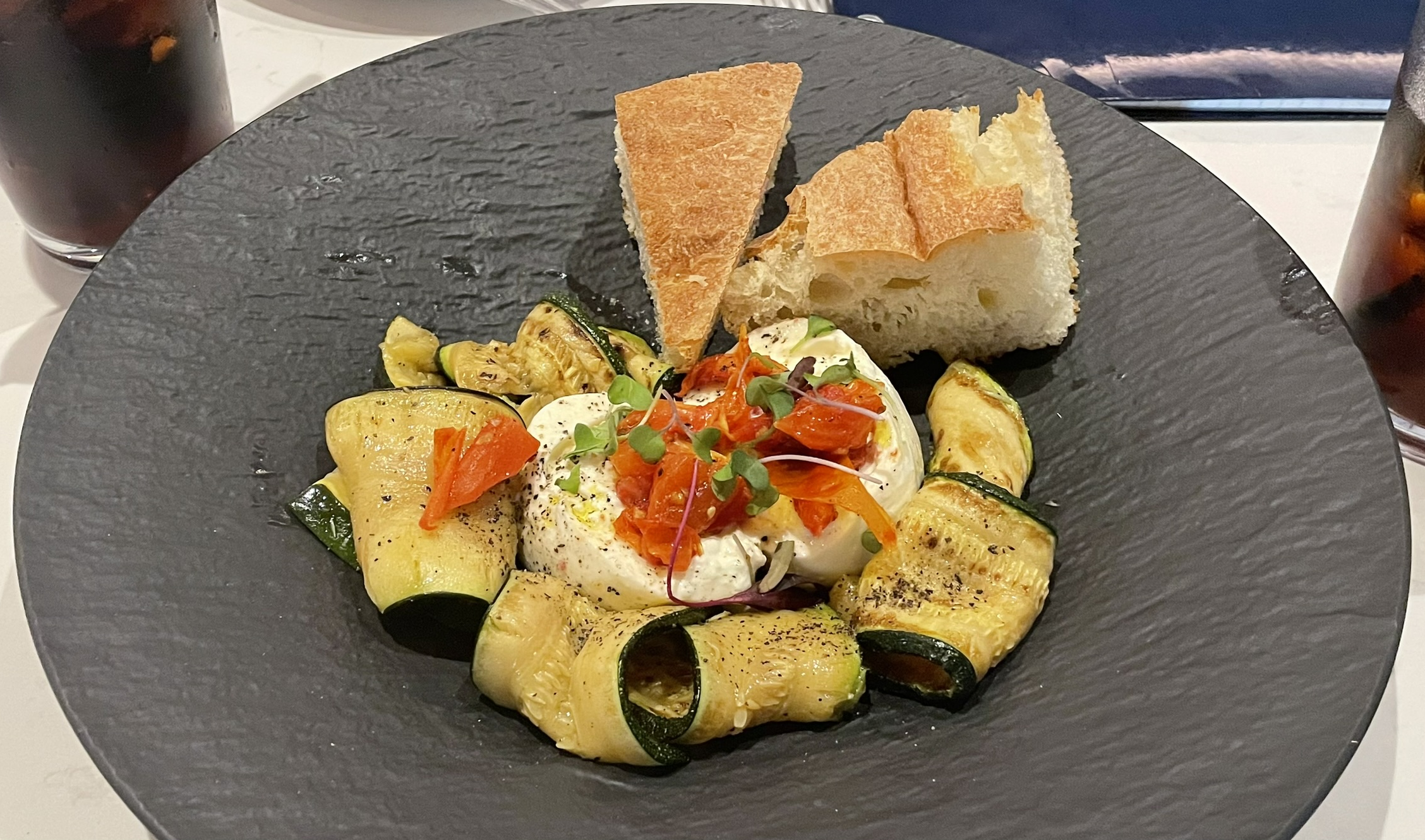 Burrata with grilled zucchini, focaccia, and confit tomatoes at Matteo Ristorante Italiano