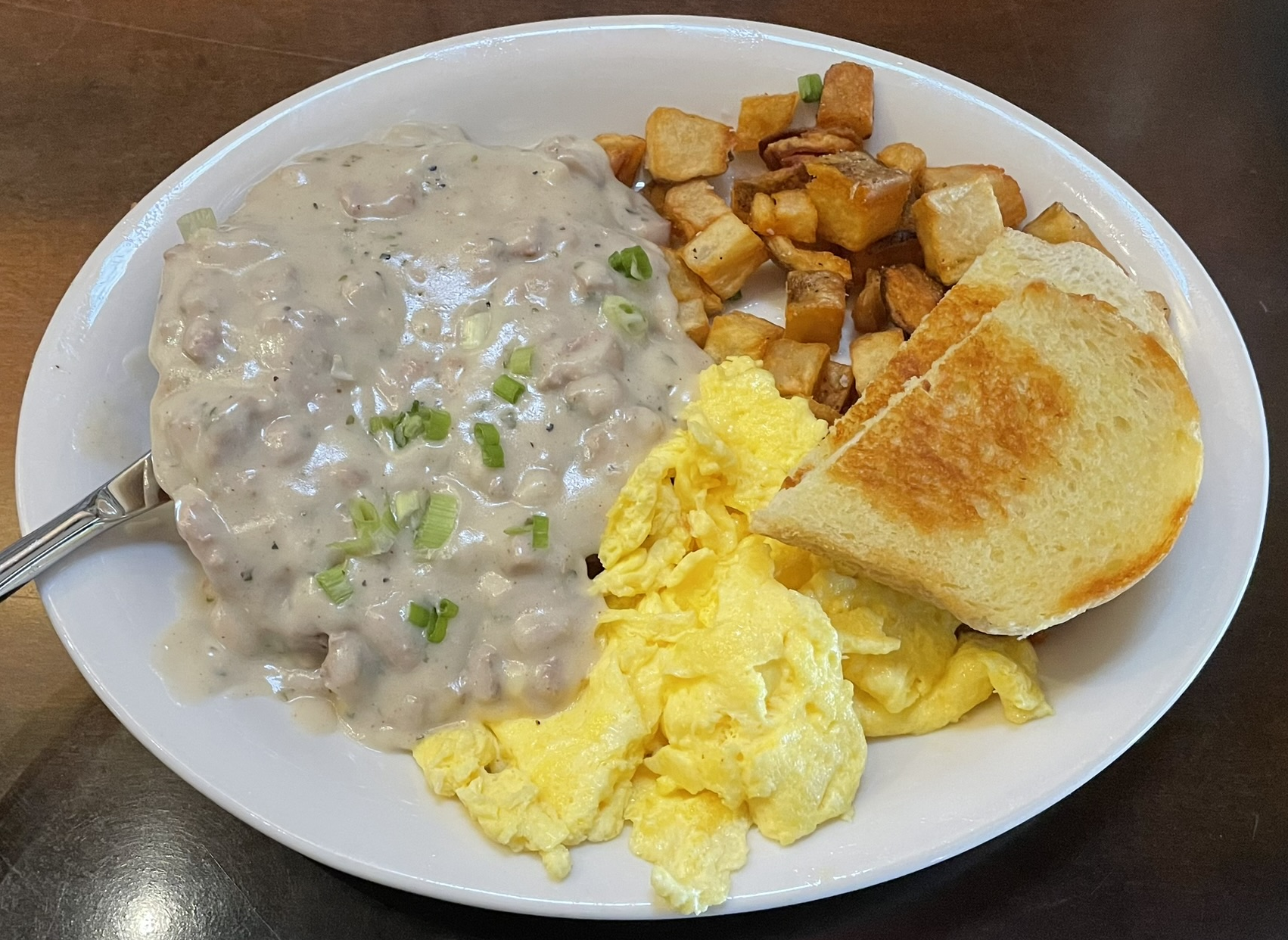 Half-pound Angus beef smothered in sausage & herb country gravy with 2 eggs, breakfast potatoes, and sourdough toast at Piper Down.