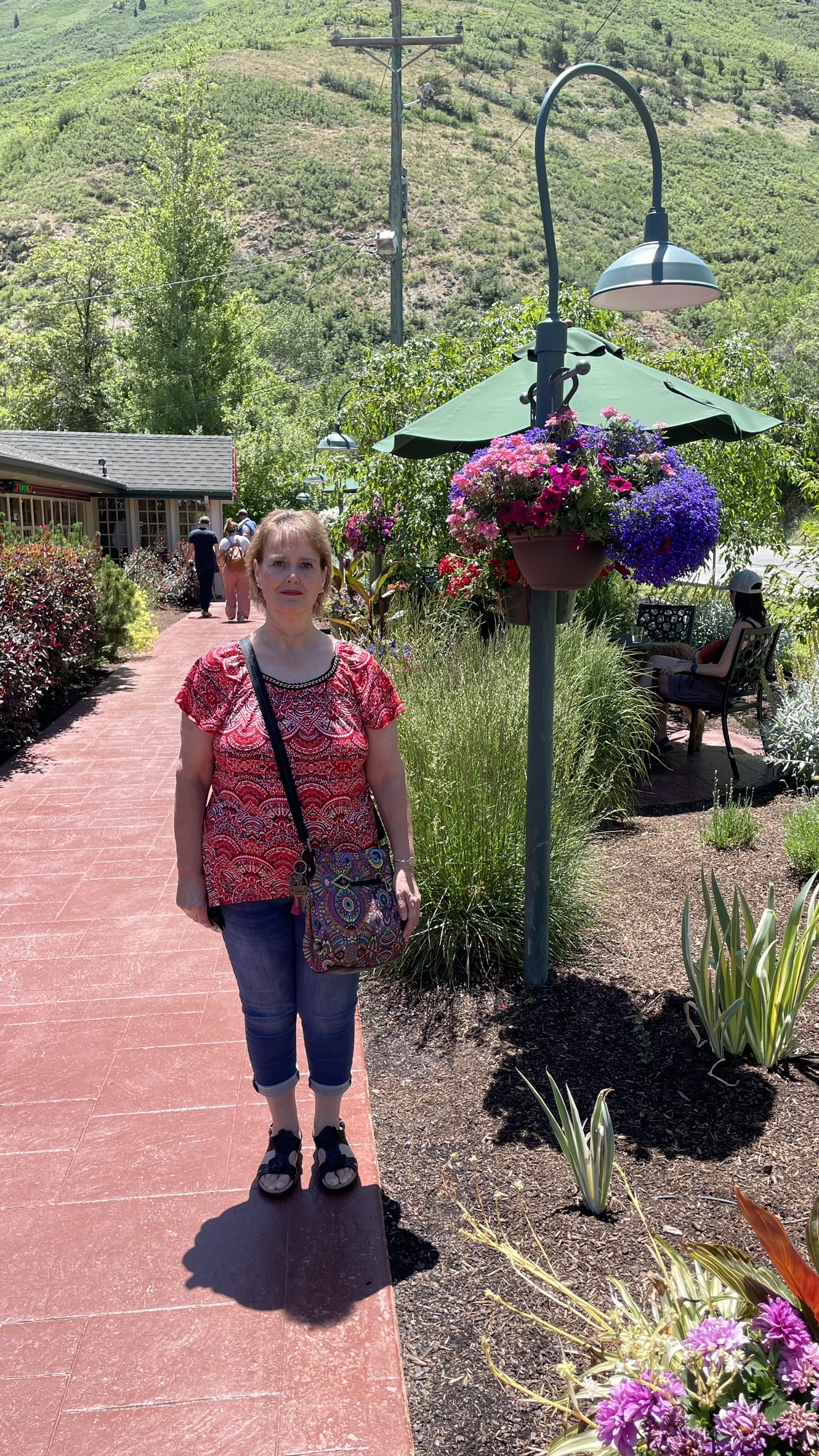 Kathy stands next to flowers near the entrance of Ruth's Diner