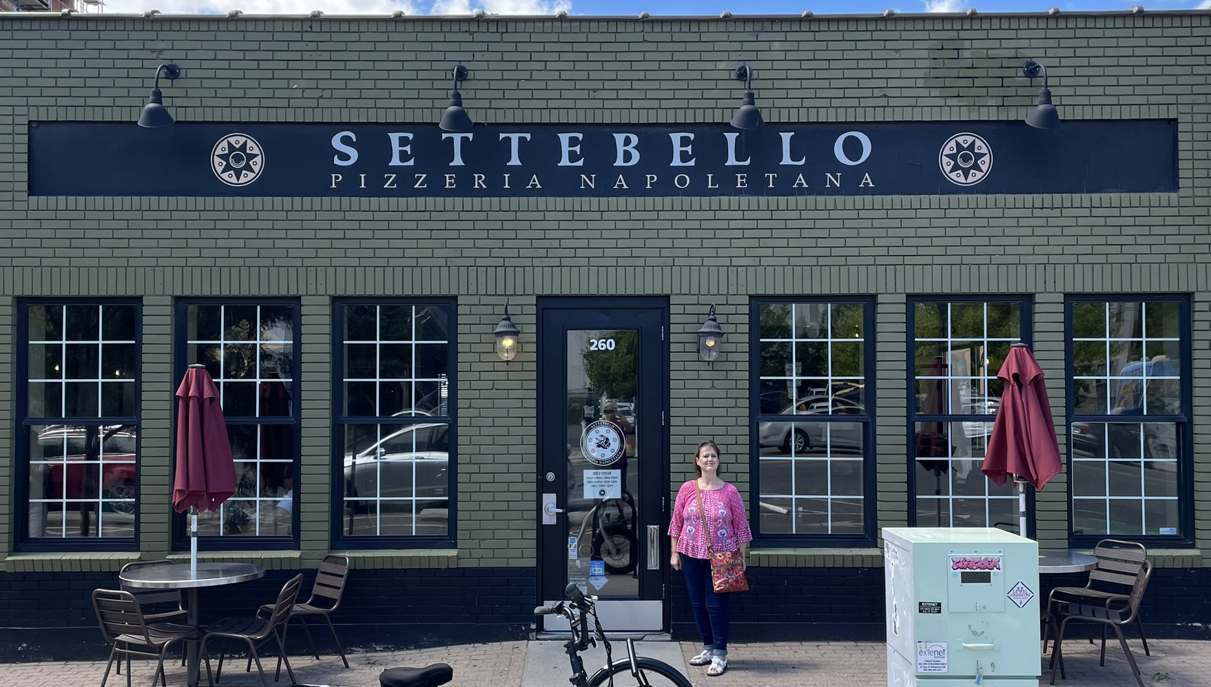 Kathy stands in front of Settebello Pizzeria Napoletana