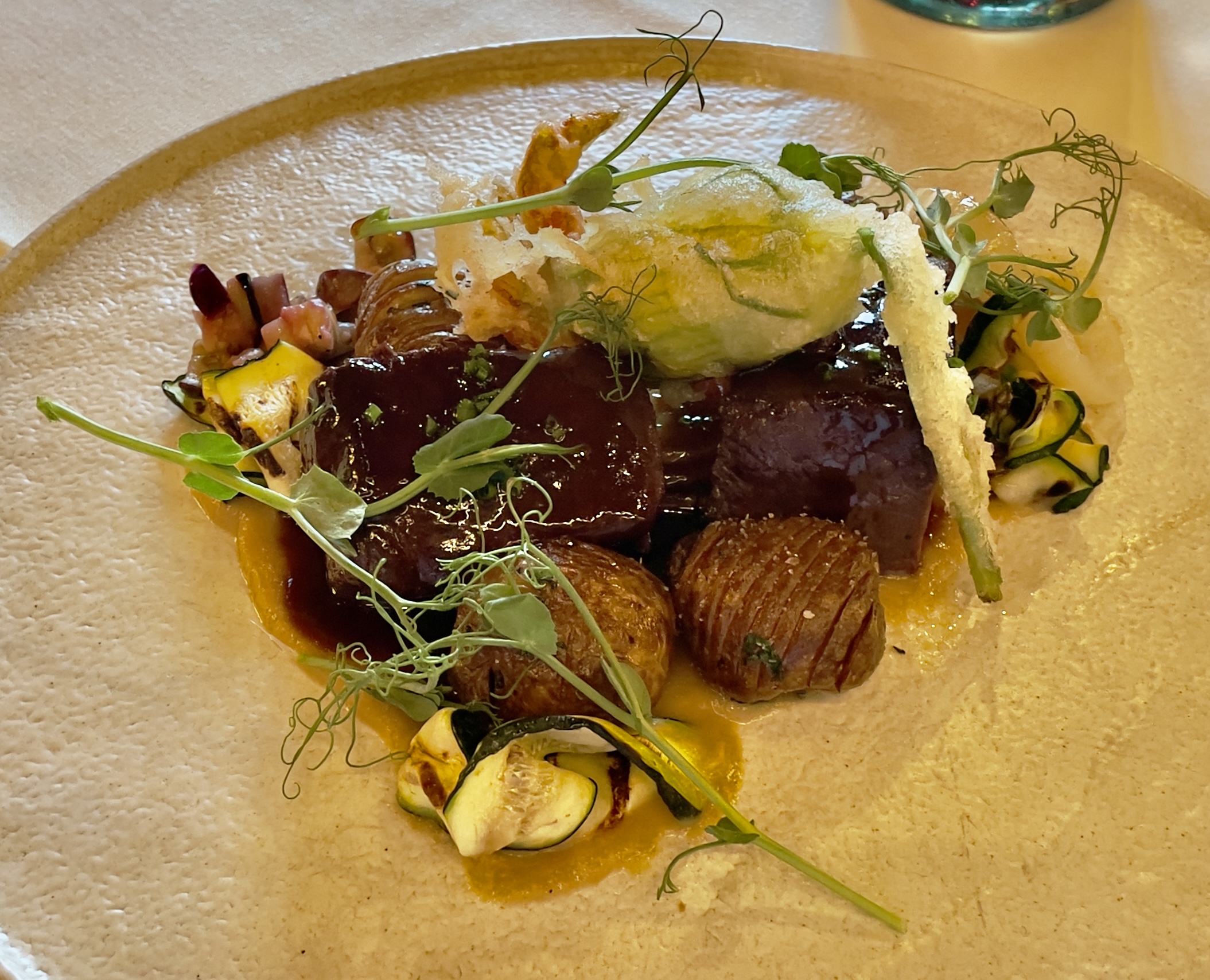 Elk Loin at the Tree Room: Ricotta-stuffed squash blossom, zucchini, eggplant, Hasselback potatoes, demi-glace.