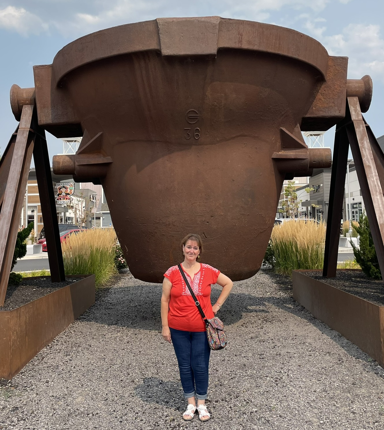 Kathy Hill stands next to a historic steel ladle at The Yard shopping center in Vineyard, Utah.