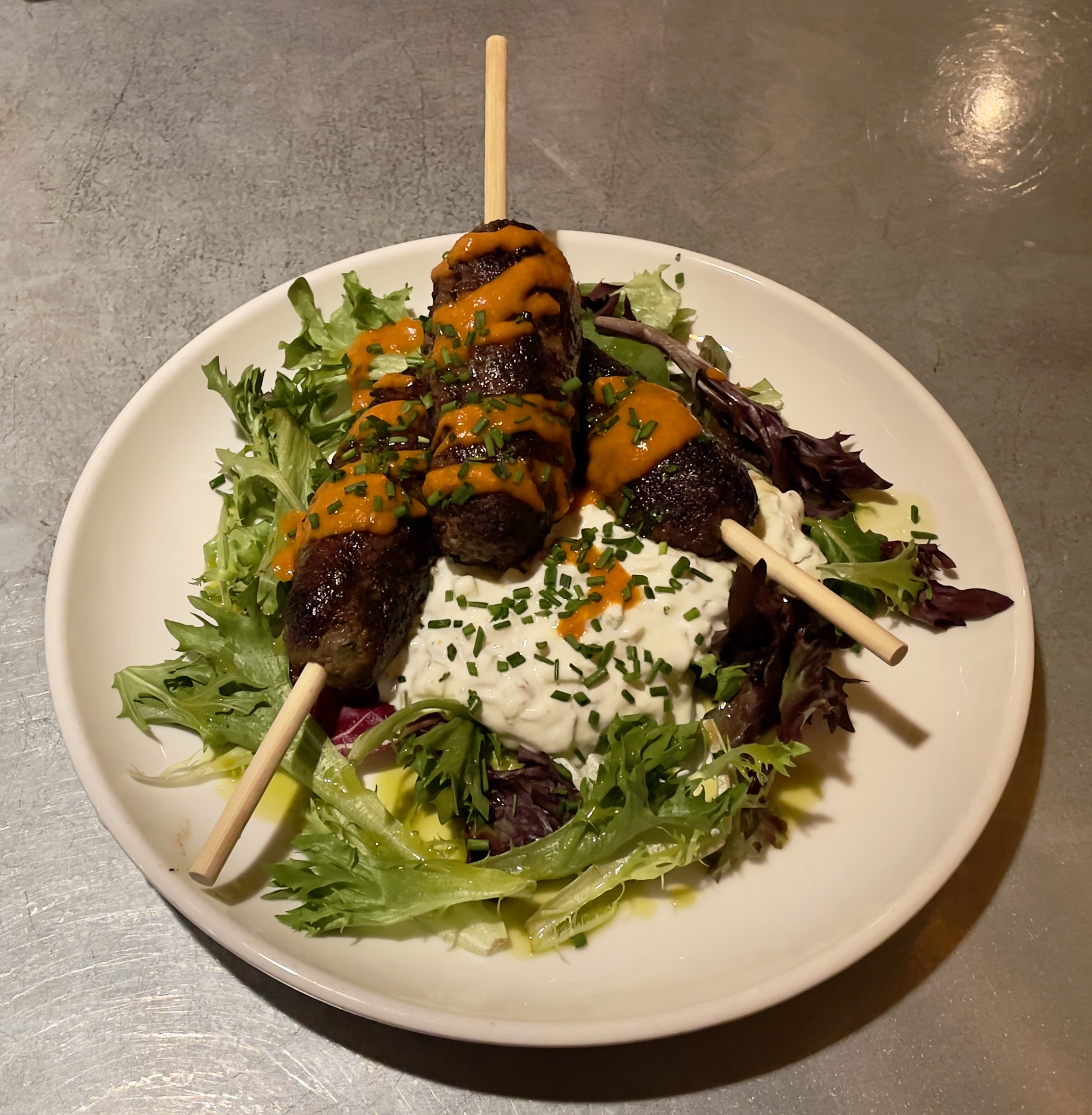 Lamb Pops with harissa, mixed greens, and cucumber raita at Wildwood Restaurant.